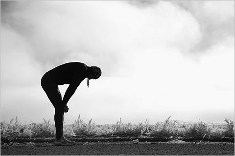 Runner bending over in exhaustion.