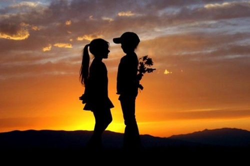 Children silhouetted against a sunset sky.