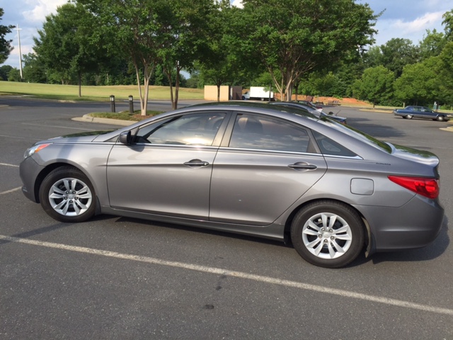 Gray sedan parked in a scenic area.