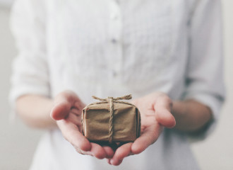 Person holding a small wrapped gift.