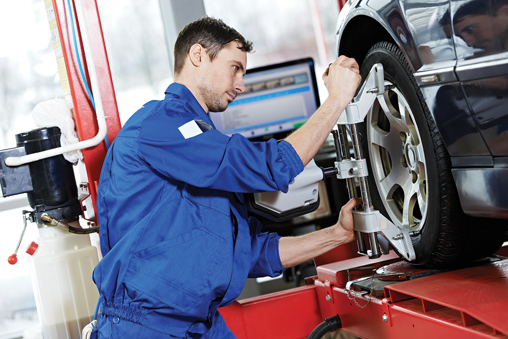 A man working on a tire in front of a computer.