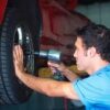 A man is working on a tire with a drill.