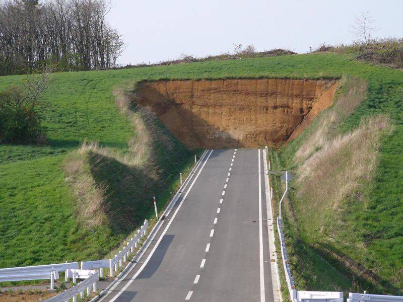 Collapsed road with eroded land edges.