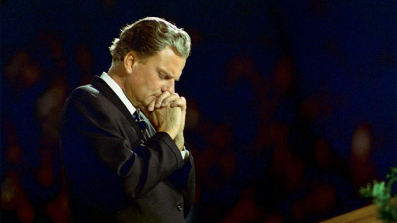 Person praying with hands clasped together.