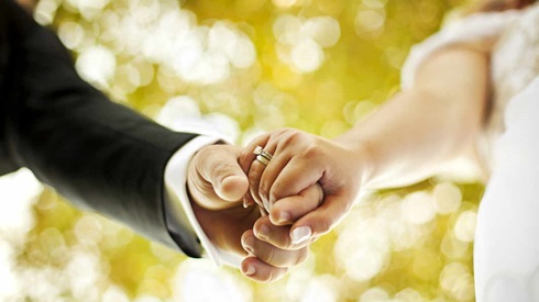 Holding hands with wedding rings.