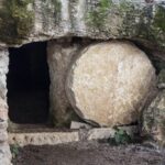 Ancient stone tomb entrance with round door.