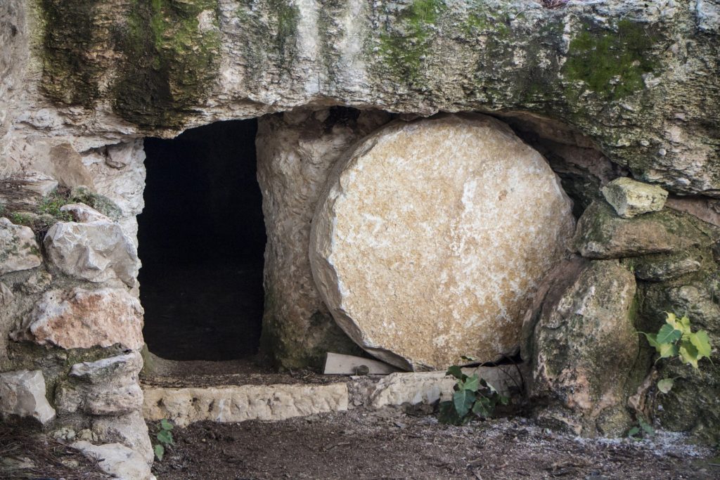 Ancient stone tomb entrance with round door.