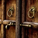 Wooden doors with brass handles and locks.