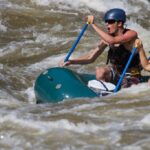 Whitewater rafting team navigating rough waters.