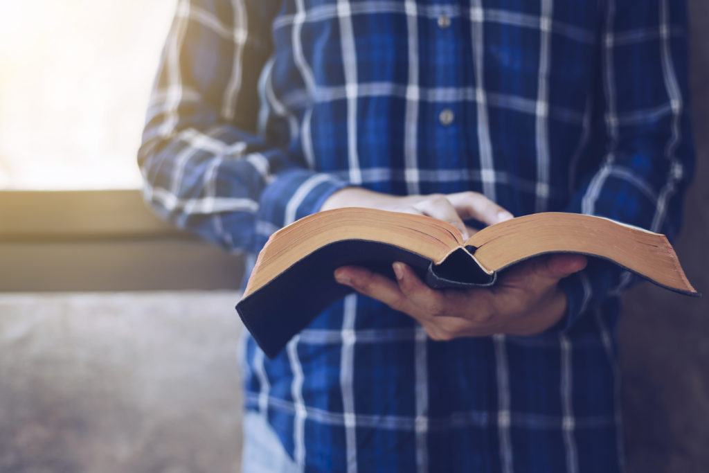 Person holding an open book indoors.