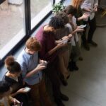 Group of people using smartphones indoors.