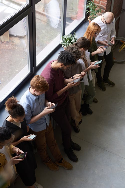 Group of people using smartphones indoors.