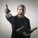 Angry man shouting while holding a book.