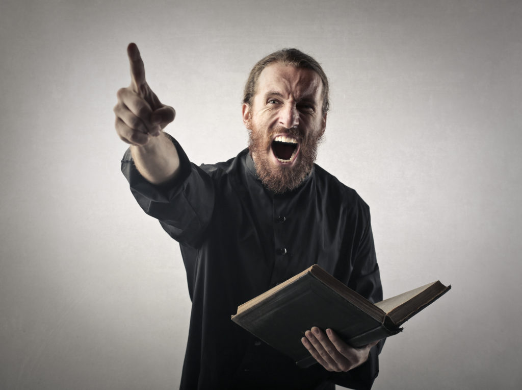 Angry man shouting while holding a book.