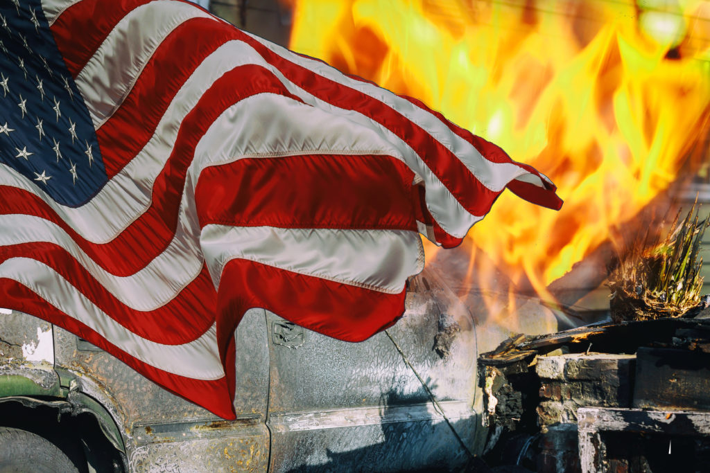 American flag waving near flames.