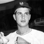 Baseball player holding a ball and glove.