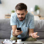 Man looking frustrated at his smartphone.