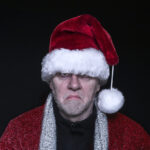 Angry man wearing a Santa hat.