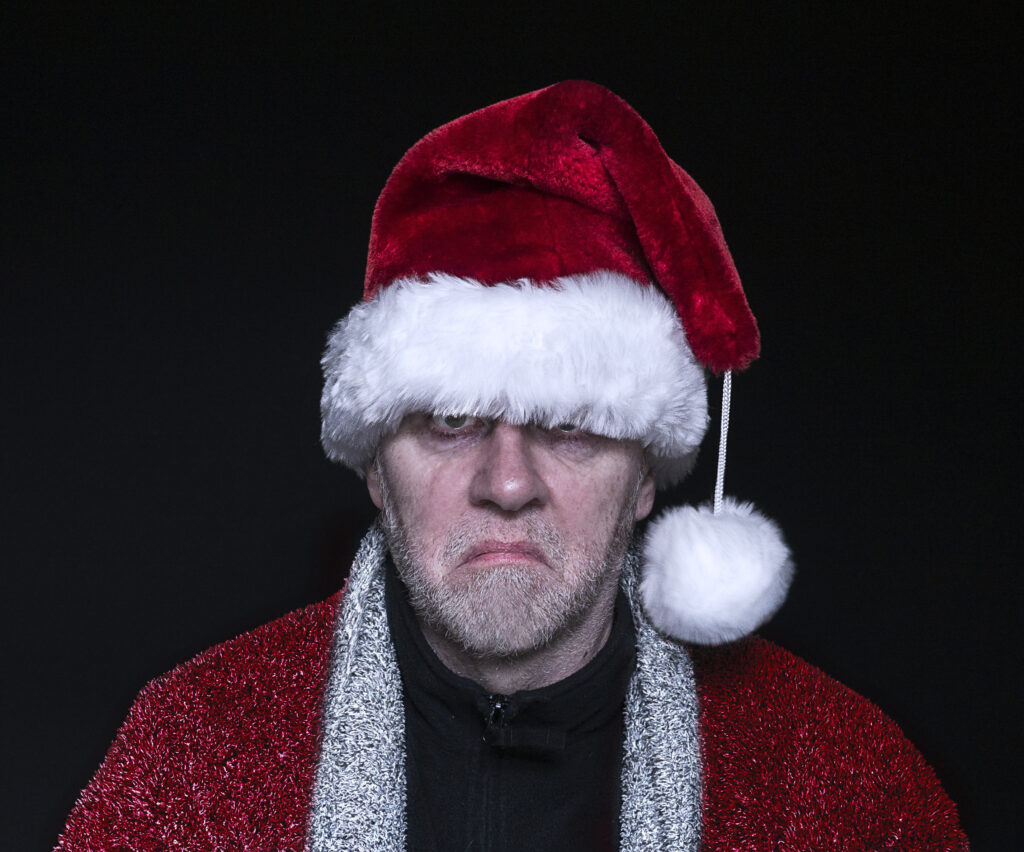 Angry man wearing a Santa hat.