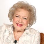 Smiling elderly woman with curly hair.