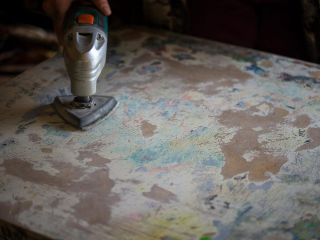 Person using a sander on a surface.