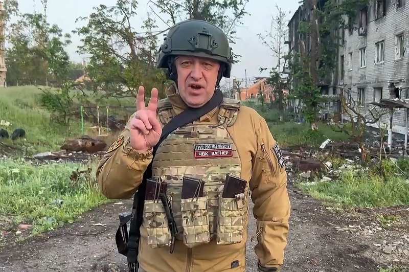 A man in military gear giving the peace sign.